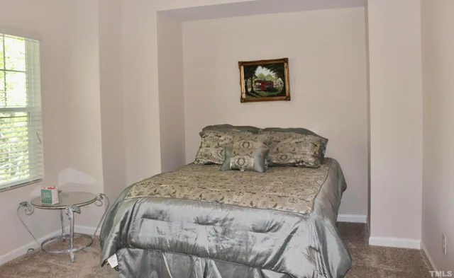 a bedroom with a bed and painting on the wall