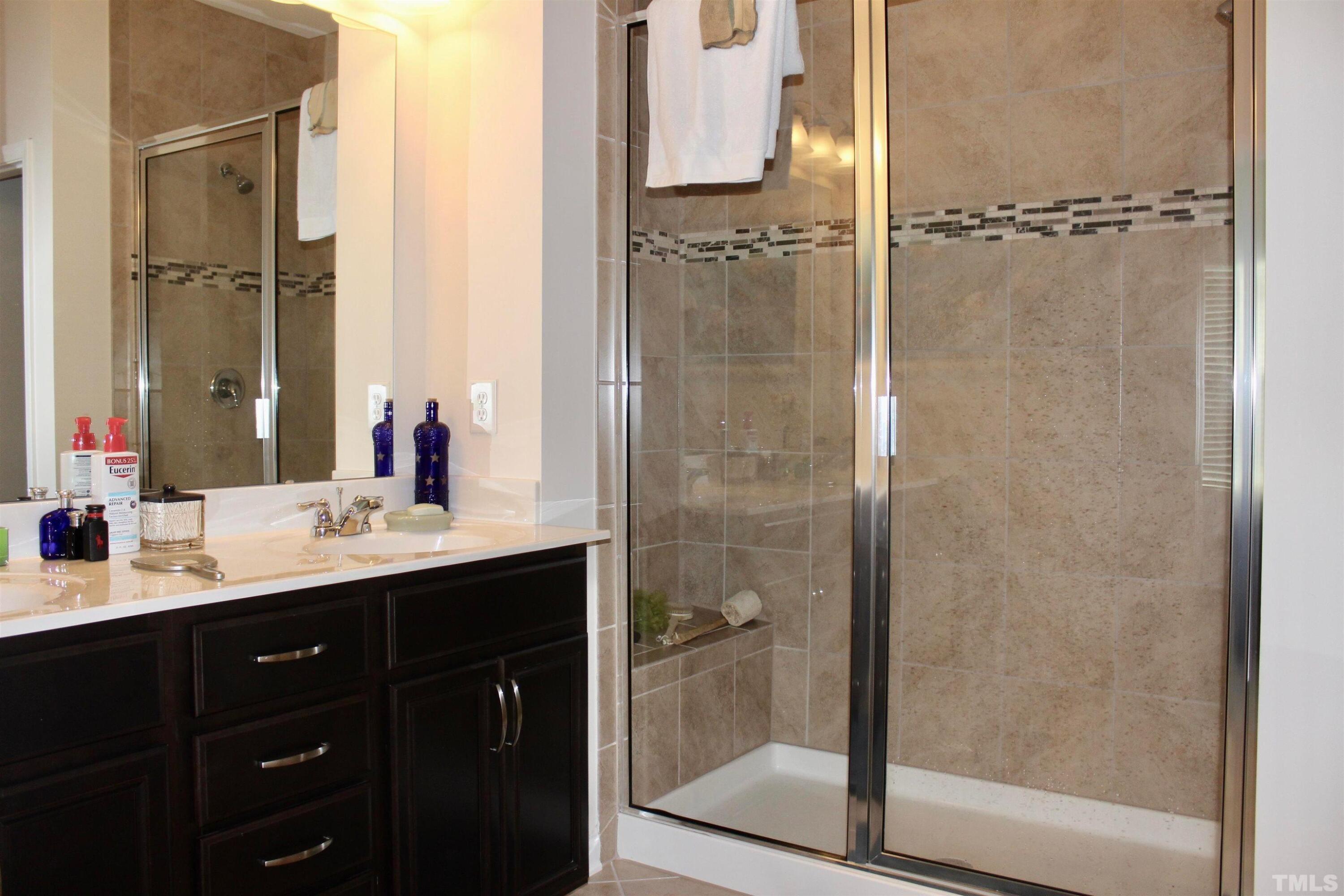 1608 Topaz Lane Apex, NC 27502 - Photo 13 of 23 a bathroom with a double vanity sink mirror and shower