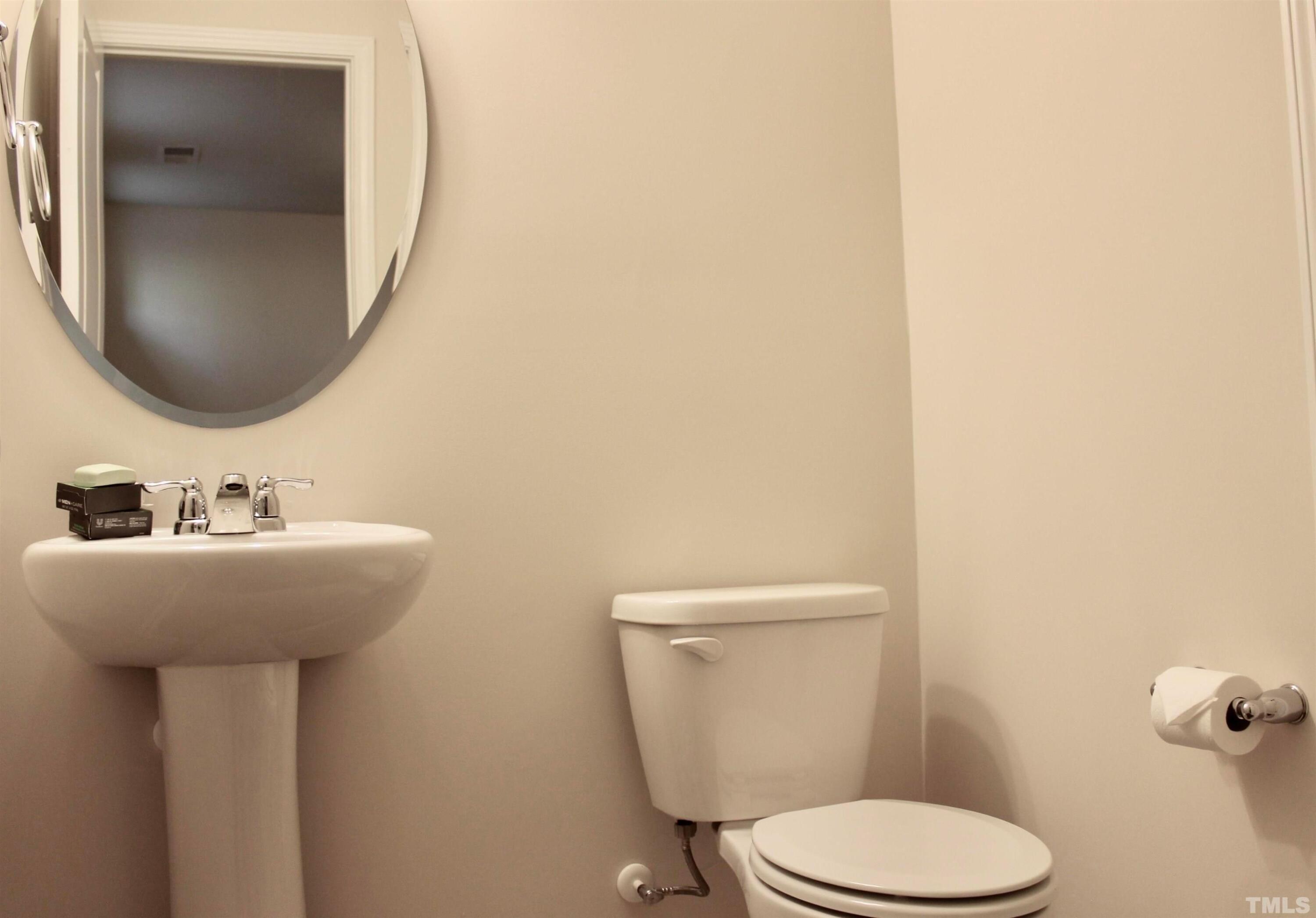 1608 Topaz Lane Apex, NC 27502 - Photo 19 of 23 a bathroom with a toilet sink and mirror