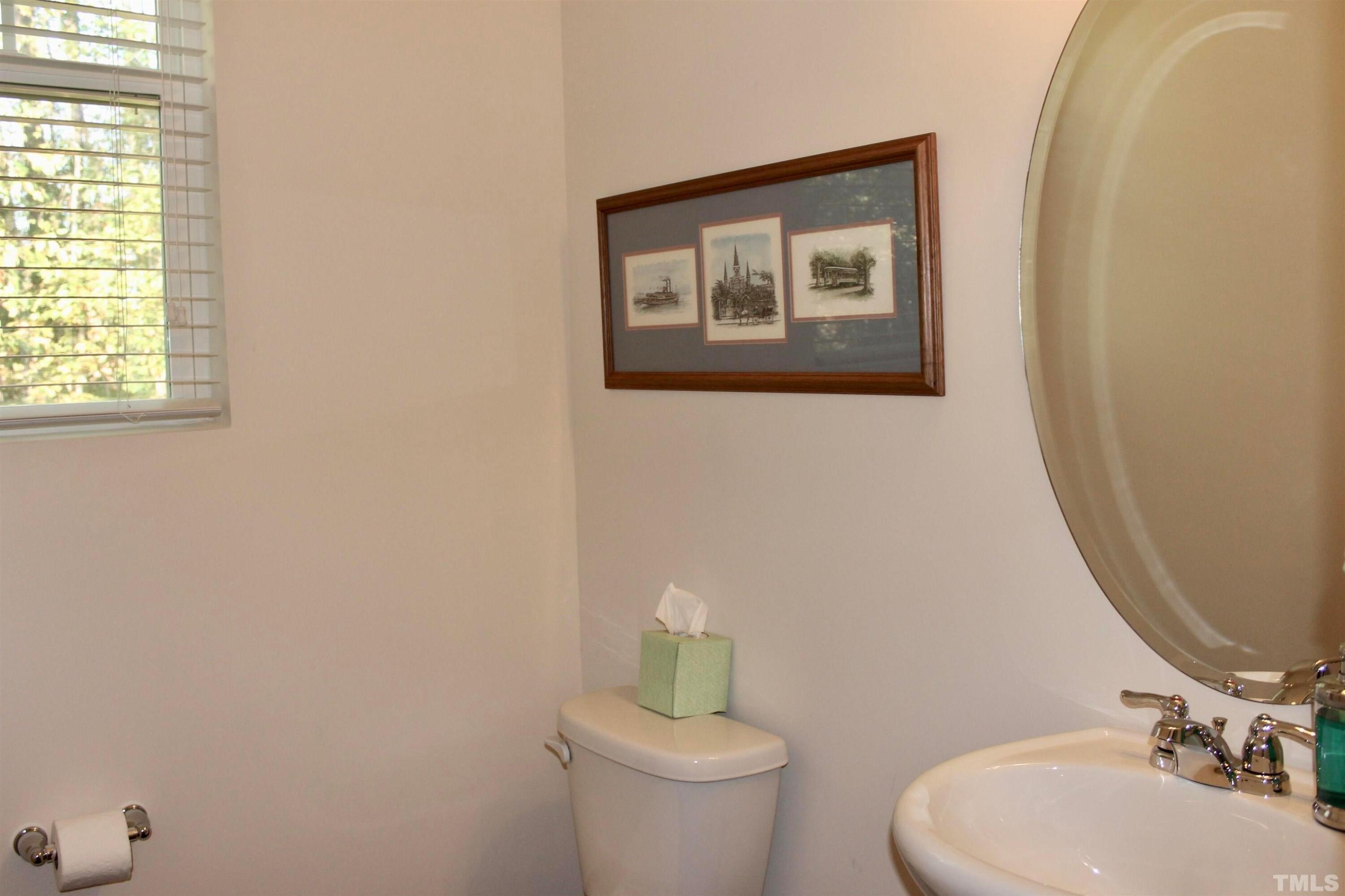 1608 Topaz Lane Apex, NC 27502 - Photo 21 of 23 a bathroom with a toilet a sink and mirror