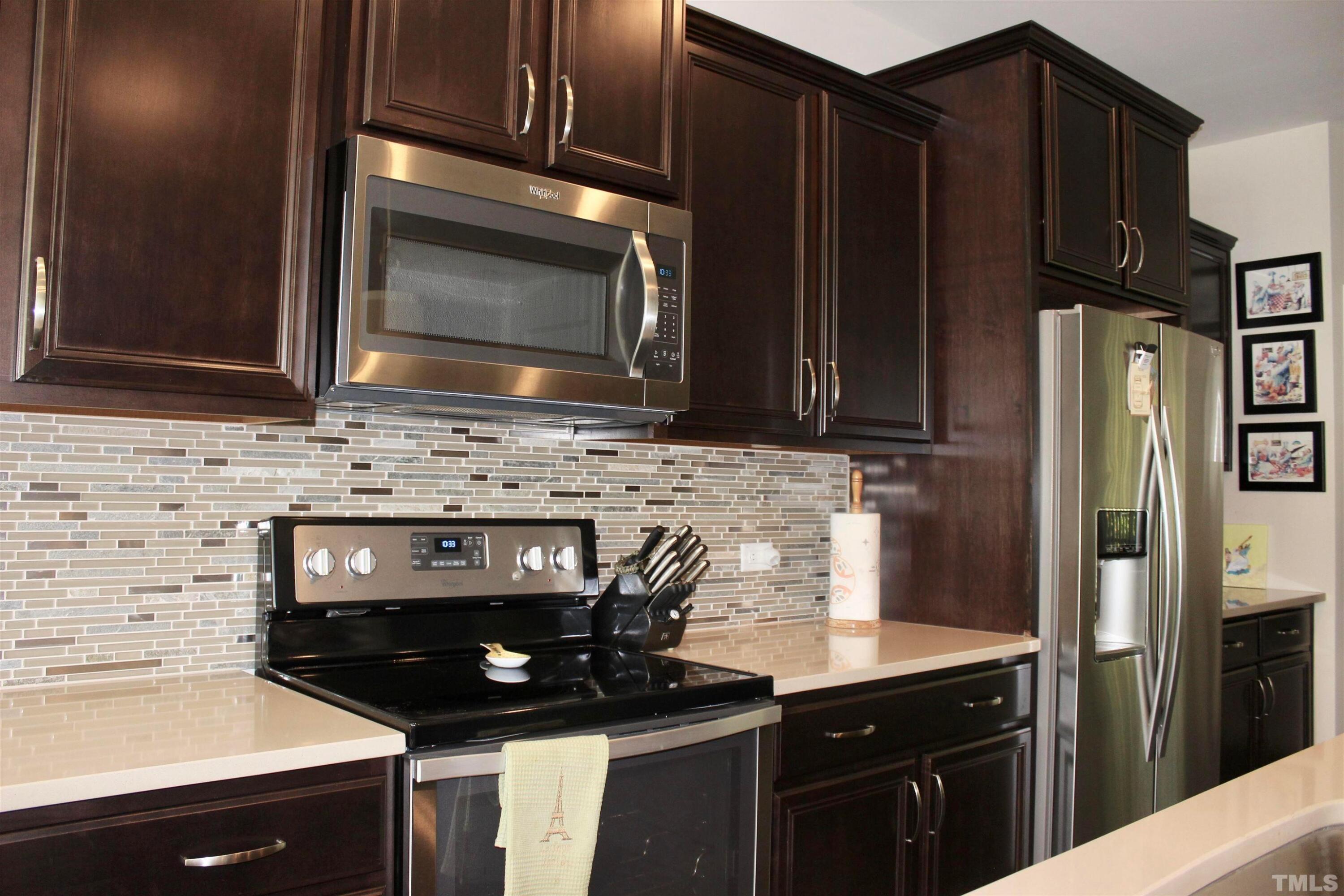 1608 Topaz Lane Apex, NC 27502 - Photo 5 of 23 a kitchen with stainless steel appliances a stove a microwave a sink and cabinets