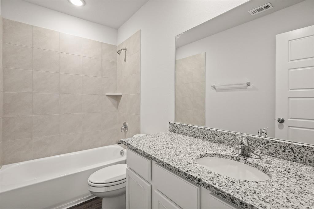 1510 Romans Road Ennis, TX 75119 - Photo 15 of 22 a bathroom with a granite countertop sink a toilet and shower
