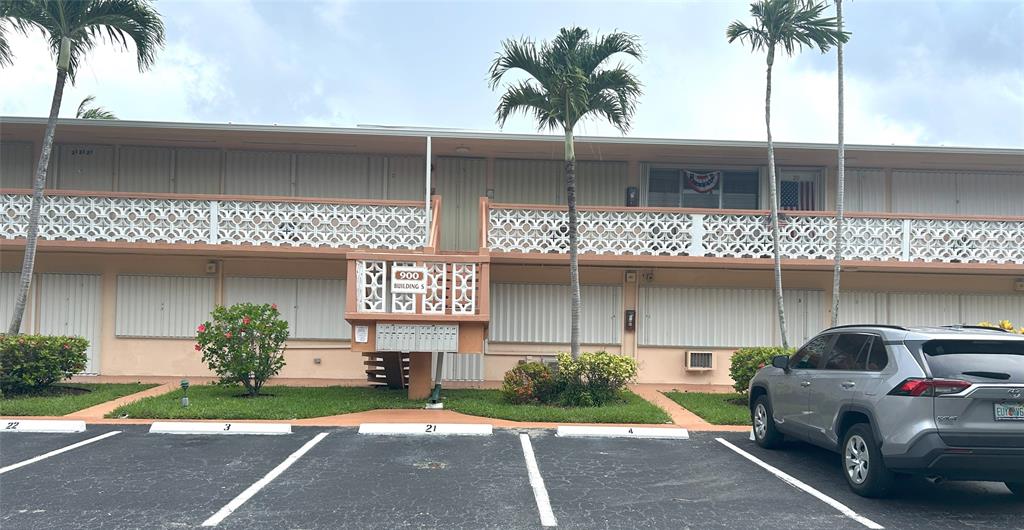 900 Southwest 10th Terrace, Unit S20 Hallandale Beach, FL 33009 - Photo 19 of 20 a front view of a house with a garden and a garage