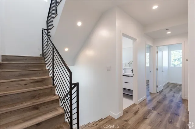 a view of a hallway with wooden floor and staircase