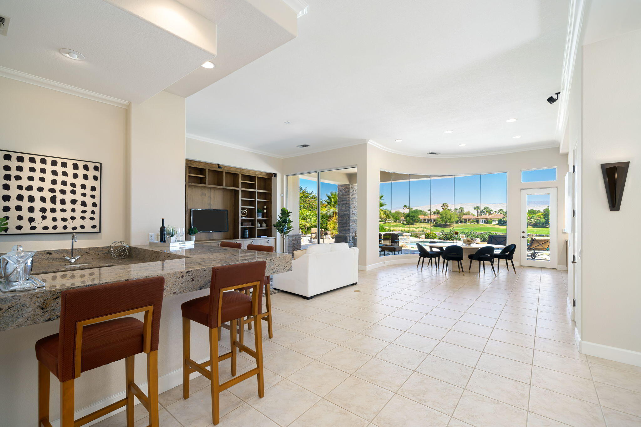 142 Loch Lomond Road Rancho Mirage, CA 92270 - Photo 11 of 62 a kitchen with stainless steel appliances granite countertop a table and chairs in it