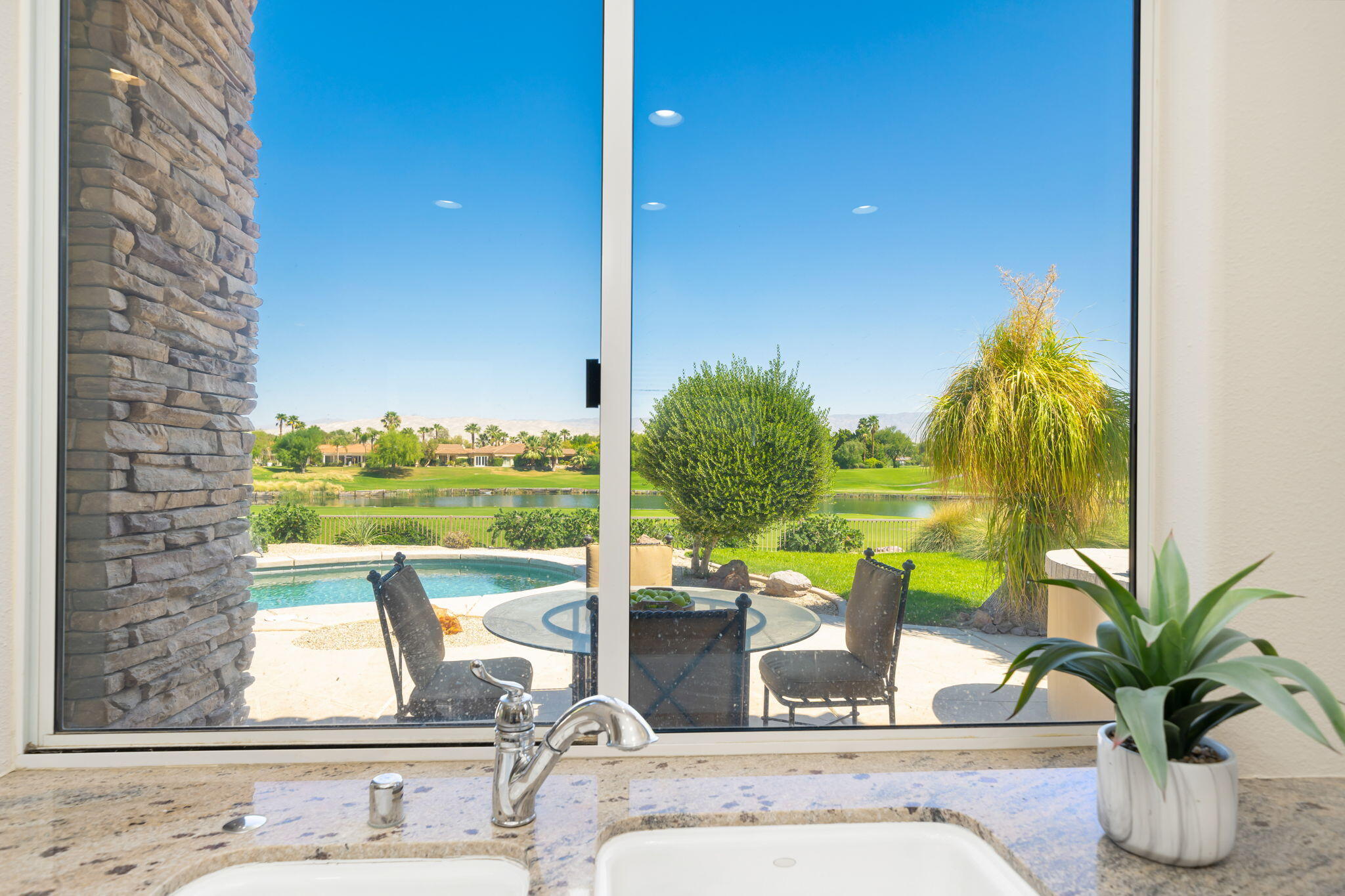 142 Loch Lomond Road Rancho Mirage, CA 92270 - Photo 18 of 62 a vase of flowers sitting on a table with a window