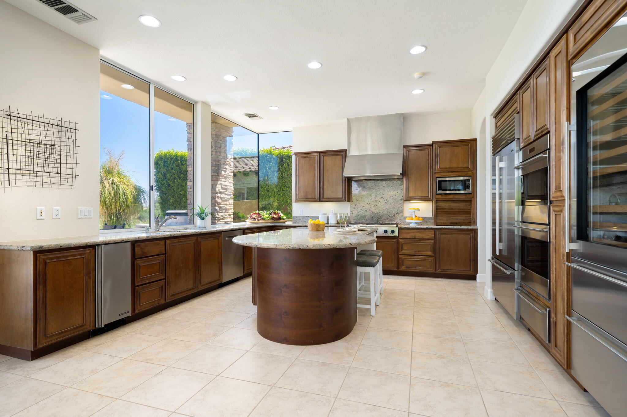 142 Loch Lomond Road Rancho Mirage, CA 92270 - Photo 35 of 62 a large kitchen with a large counter top a sink a refrigerator and cabinets