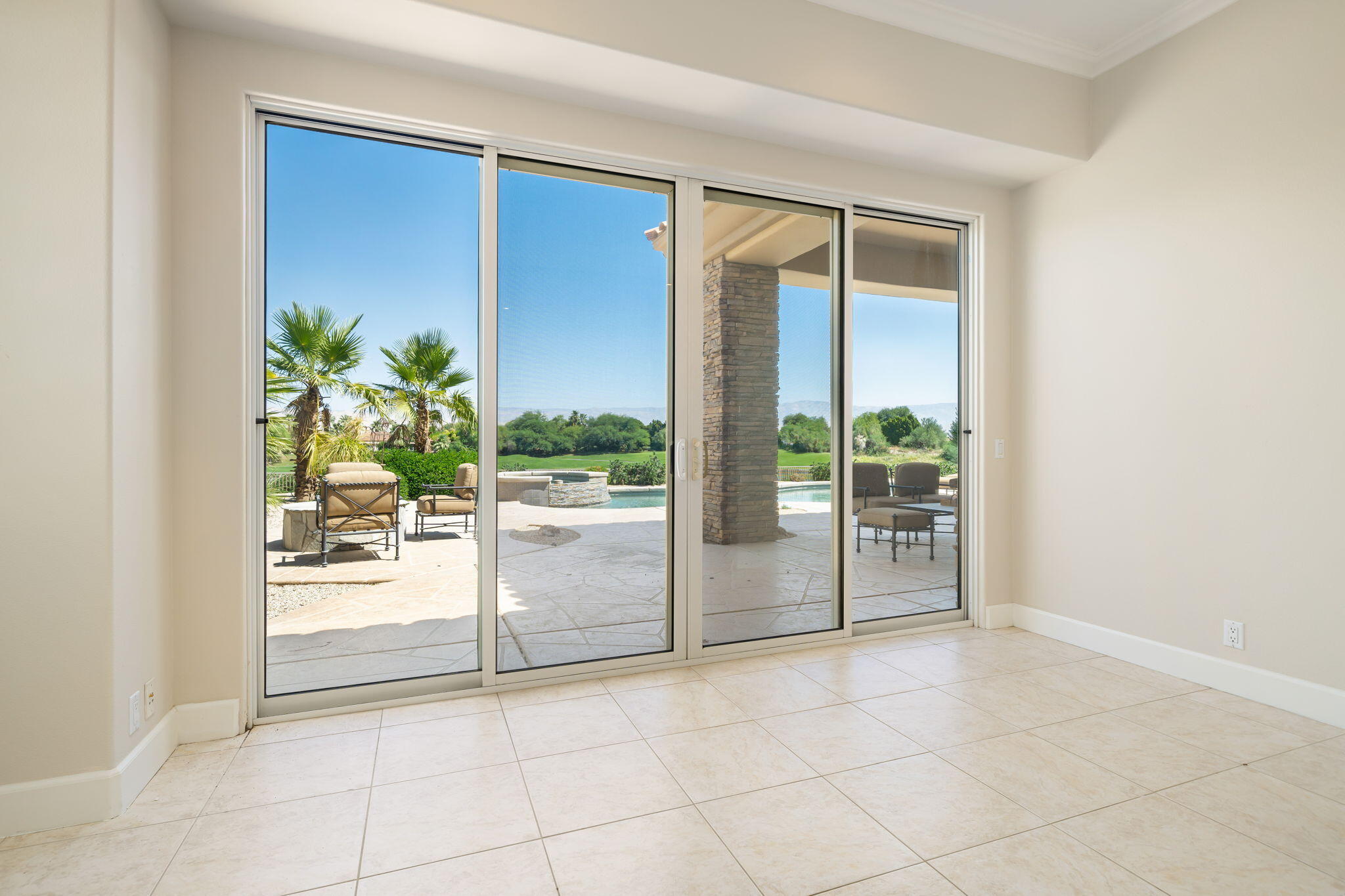 142 Loch Lomond Road Rancho Mirage, CA 92270 - Photo 40 of 62 a view of a livingroom with a floor to ceiling window and potted plants