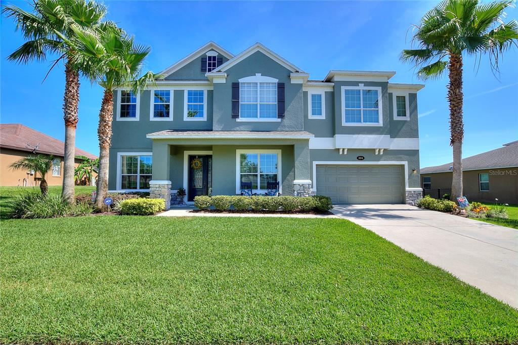 a front view of a house with yard and green space