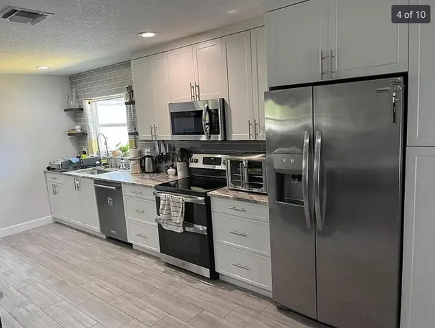 a kitchen with a refrigerator sink and microwave