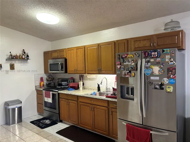 a kitchen with stainless steel appliances a refrigerator and a stove top oven
