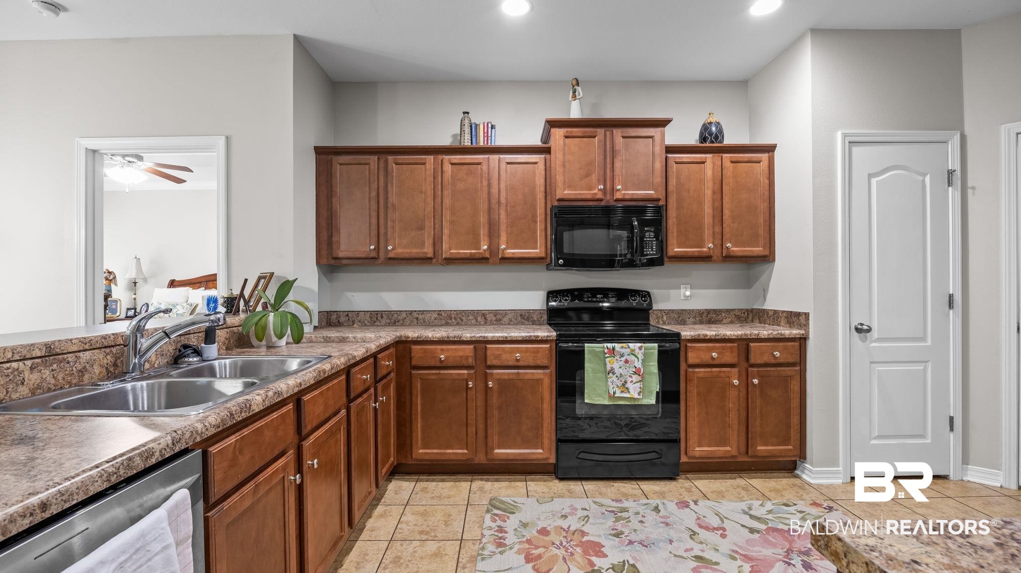 1090 Melbourne Court Foley, AL 36535 - Photo 35 of 38 Kitchen featuring black appliances, wood finish cabinetry, ceiling fan, and dark countertops