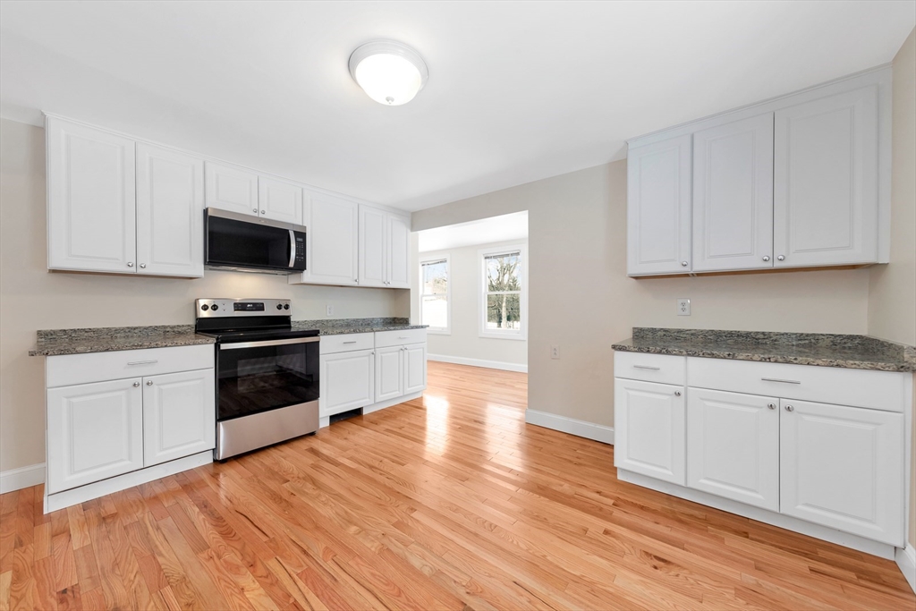 92 Squannacook Road Shirley, MA 01464 - Photo 15 of 22 a kitchen with granite countertop a stove top oven a sink and white cabinets
