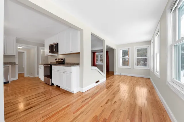 a view of kitchen with wooden floor and electronic appliances