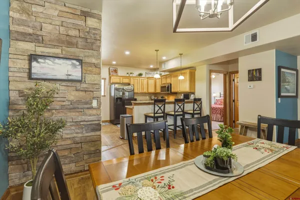 a view of a dining room with furniture a chandelier and wooden floor