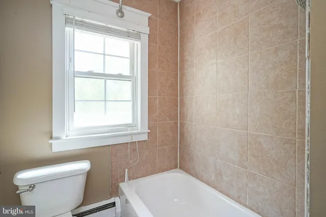 a bathroom with a toilet a sink a window and vanity