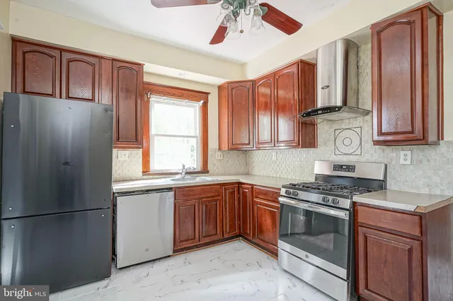 a kitchen with stainless steel appliances granite countertop a refrigerator a sink dishwasher a stove and white countertops with cabinets