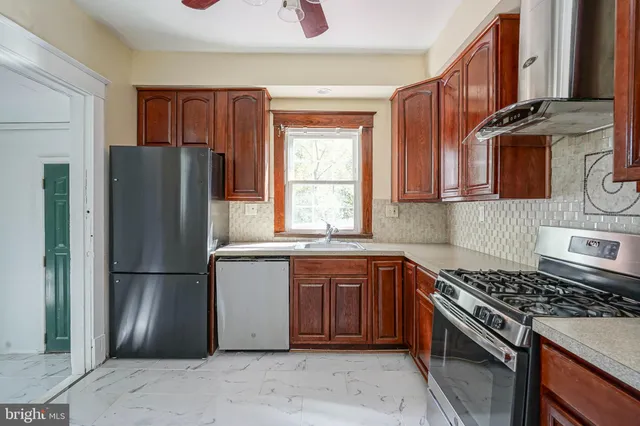 a kitchen with stainless steel appliances granite countertop a refrigerator stove and sink