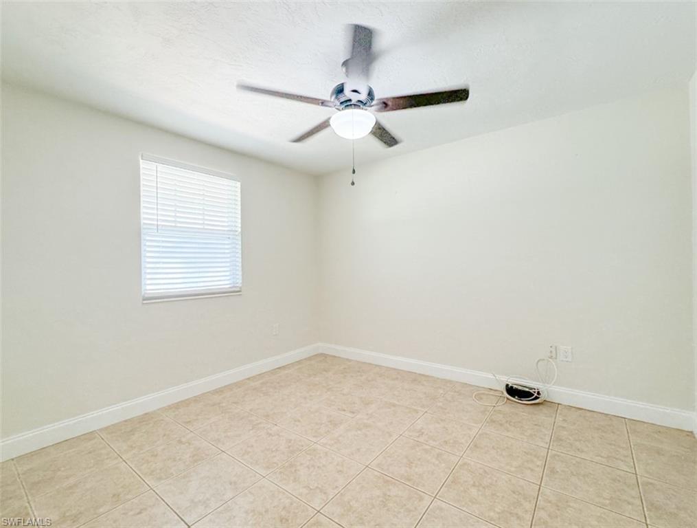 746 109th Avenue North Naples, FL 34108 - Photo 13 of 22 an empty room with a ceiling fan and a window