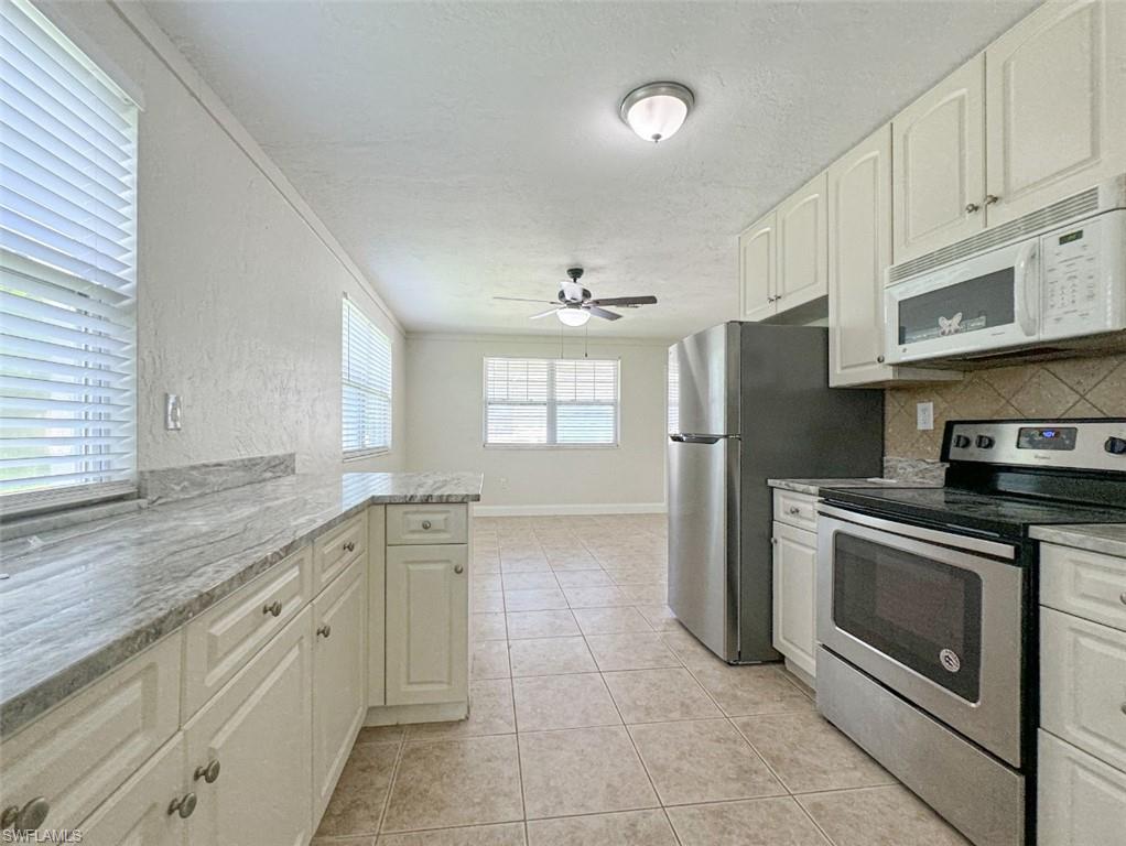 746 109th Avenue North Naples, FL 34108 - Photo 5 of 22 a kitchen with stainless steel appliances granite countertop a refrigerator and a stove top oven