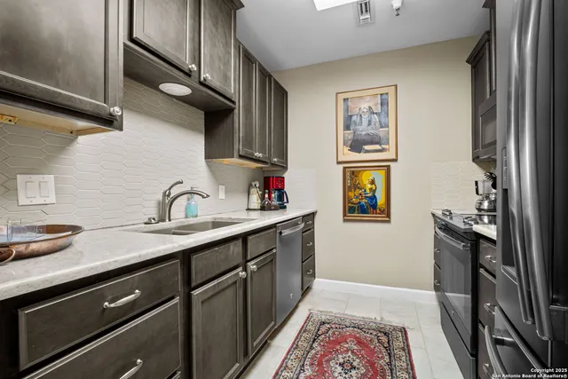 a kitchen with stainless steel appliances granite countertop a sink stove and cabinets