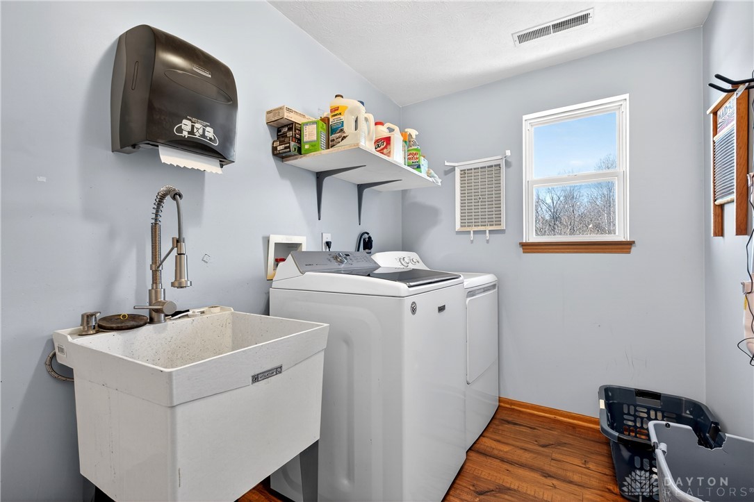 6560 Snyder Road Fletcher, OH 45326 - Photo 26 of 71 This functional laundry area includes a utility sink and a window, ideal for everyday chores.