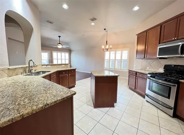 a kitchen with stainless steel appliances granite countertop a sink stove and cabinets