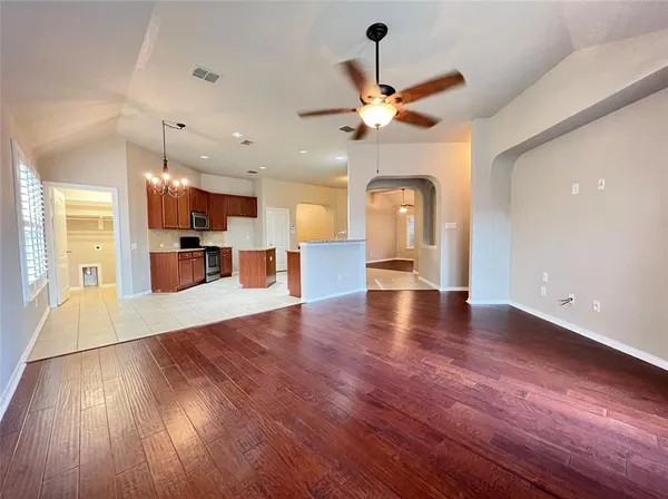 a view of a living room a wooden floor and a ceiling fan