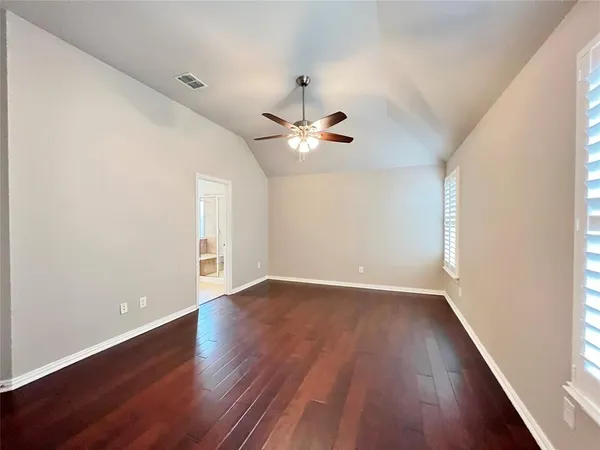 a view of an empty room with wooden floor