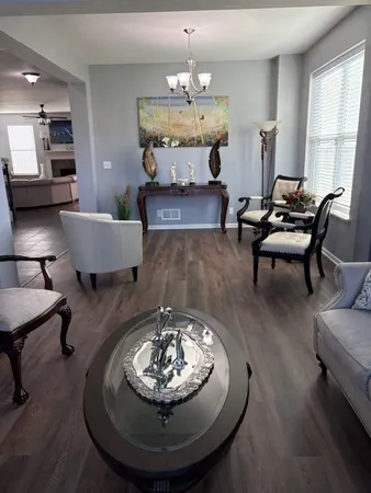 a living room with furniture and a chandelier