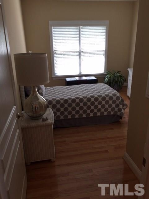 7510 Lead Mine Road, Unit 106 Raleigh, NC 27615 - Photo 14 of 22 a bedroom with a bed and wooden floor