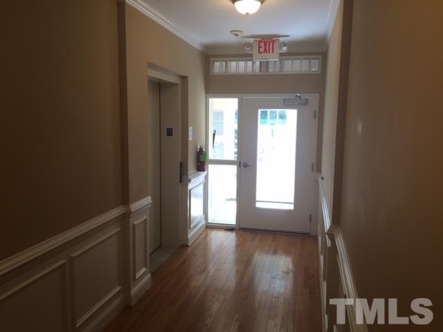 7510 Lead Mine Road, Unit 106 Raleigh, NC 27615 - Photo 3 of 22 a view of an empty room with wooden floor and a window