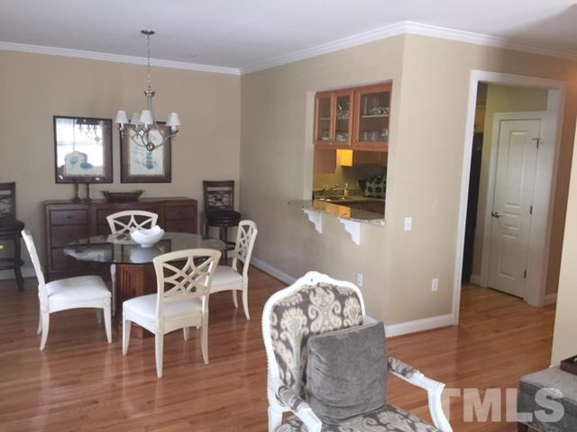 7510 Lead Mine Road, Unit 106 Raleigh, NC 27615 - Photo 7 of 22 a dining room with furniture a chandelier and wooden floor