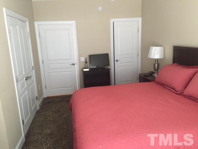 7510 Lead Mine Road, Unit 106 Raleigh, NC 27615 - Photo 10 of 22 a bedroom with a bed and a mirror