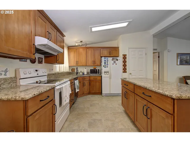 a kitchen with kitchen island granite countertop a sink counter top space and stainless steel appliances