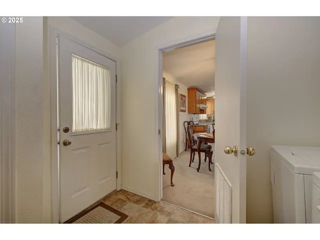 a living room with furniture kitchen view and a wooden floor