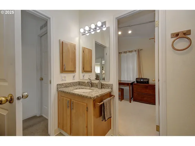 a bathroom with a granite countertop sink a mirror and a shower
