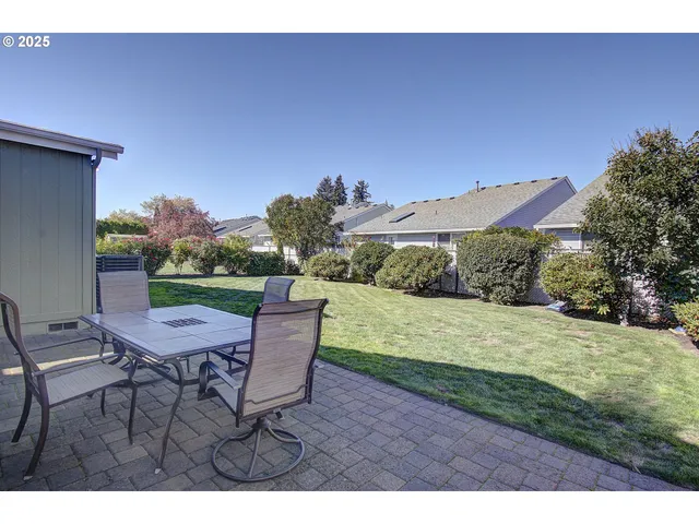 a view of a patio with table and chairs with wooden fence