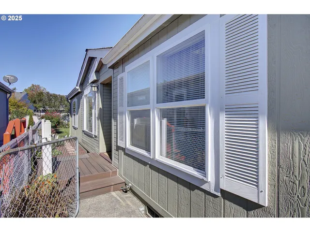 a open kitchen with stainless steel appliances granite countertop a dining table chairs and a refrigerator