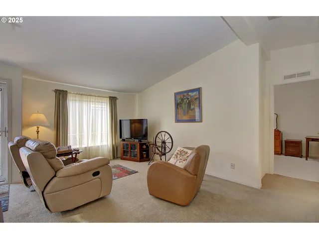 a living room with furniture a window and a flat screen tv