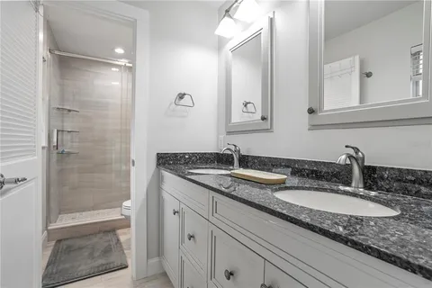 a bathroom with a granite countertop sink and a mirror