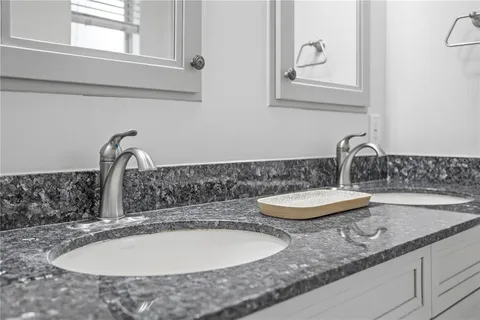 a bathroom with sinks and a window