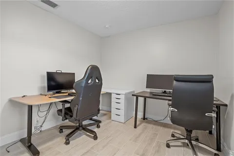 a view of a workspace with furniture and a window