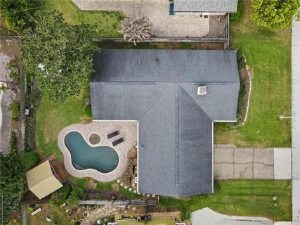 an aerial view of a house with garden space and swimming pool
