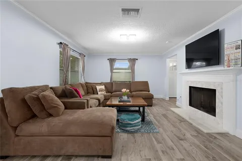 a living room with furniture a fireplace and a flat screen tv