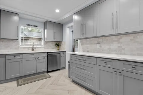 a kitchen with granite countertop white cabinets stainless steel appliances and sink
