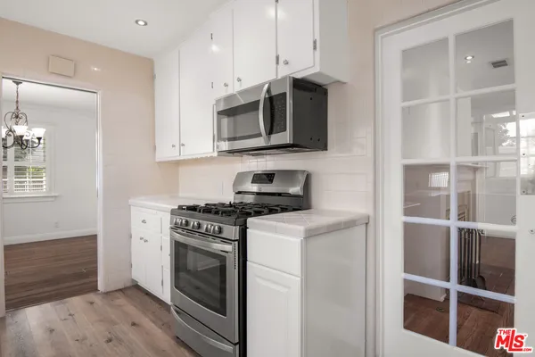 a kitchen with stainless steel appliances granite countertop a stove and a microwave