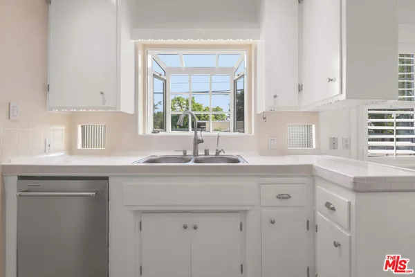 a kitchen with stainless steel appliances granite countertop a sink and a window
