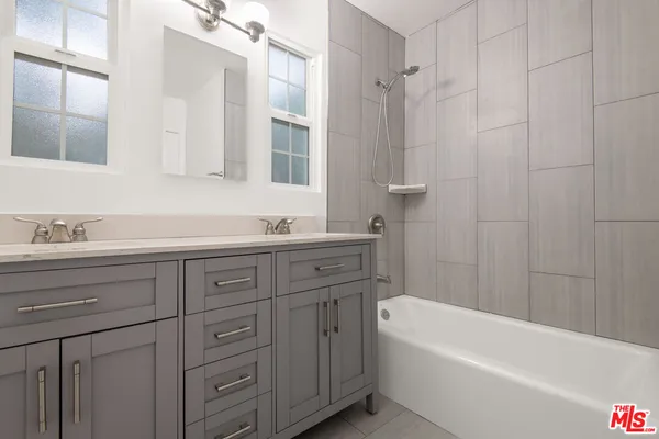 a bathroom with a tub a sink double vanity