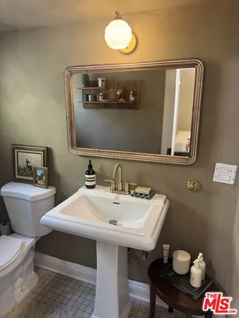 a bathroom with a sink and mirror with toilet